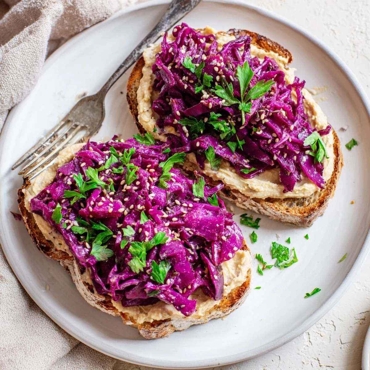Crispy toasts topped with vibrant pickled red cabbage hummus and fresh herbs.