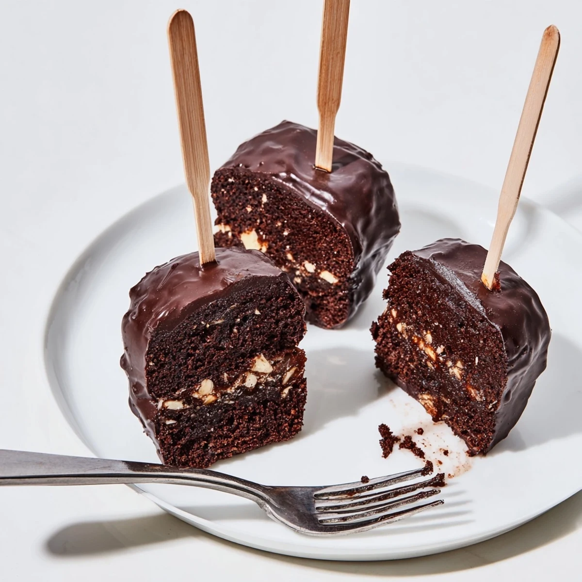 Köstliche Chaos Cake Sacher Muffin Sticks mit glänzender Schokoladenglasur und Aprikosenmarmelade.