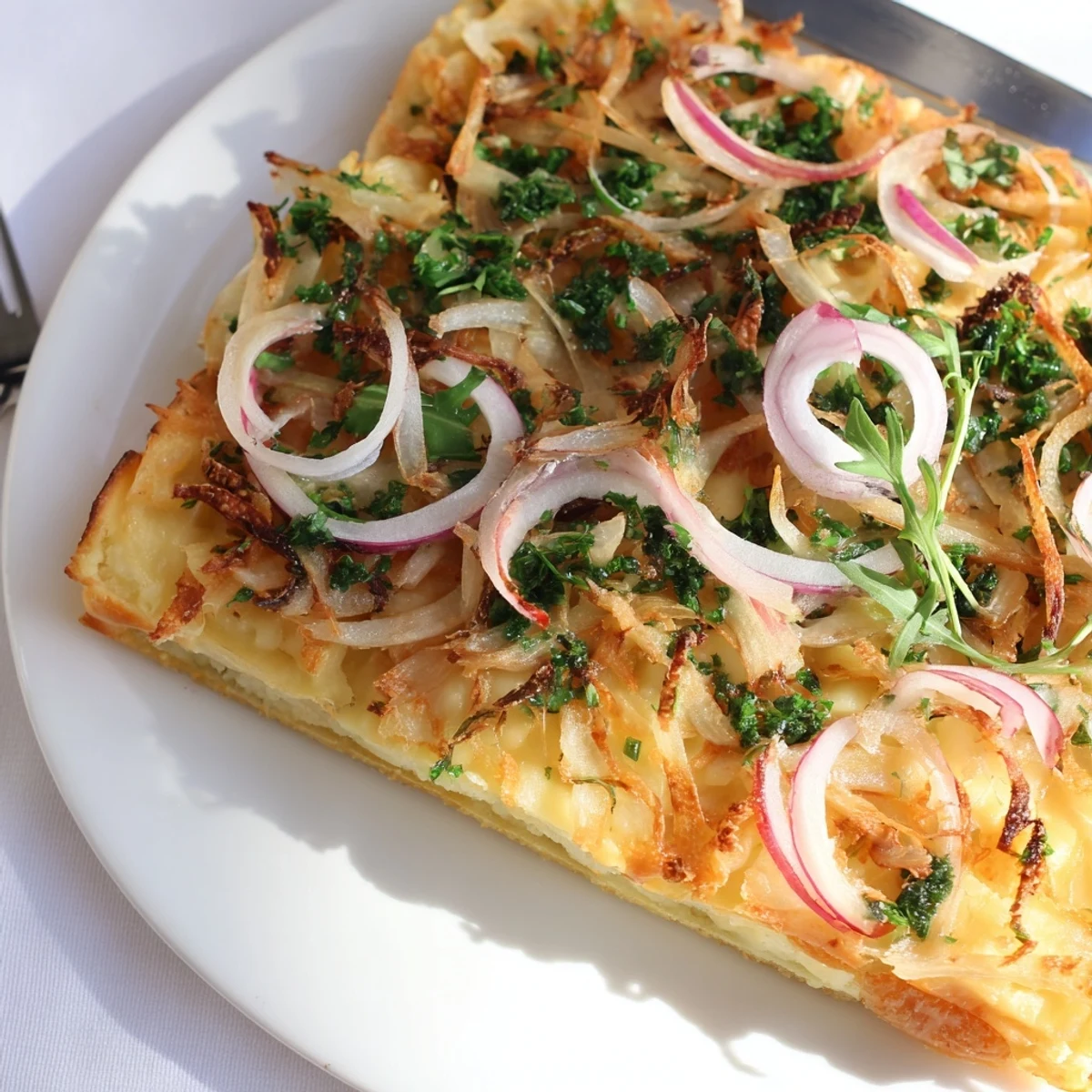 Leckeres Maultaschen-Fladenbrot, bedeckt mit cremigem Käse und frischen Kräutern.  