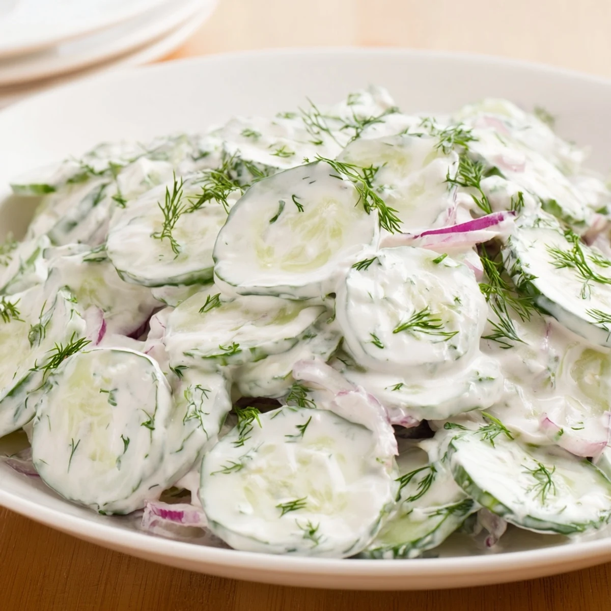 Erfrischender Omas deutscher Gurkensalat, serviert mit knusprigem Brot und Zwiebeln.  