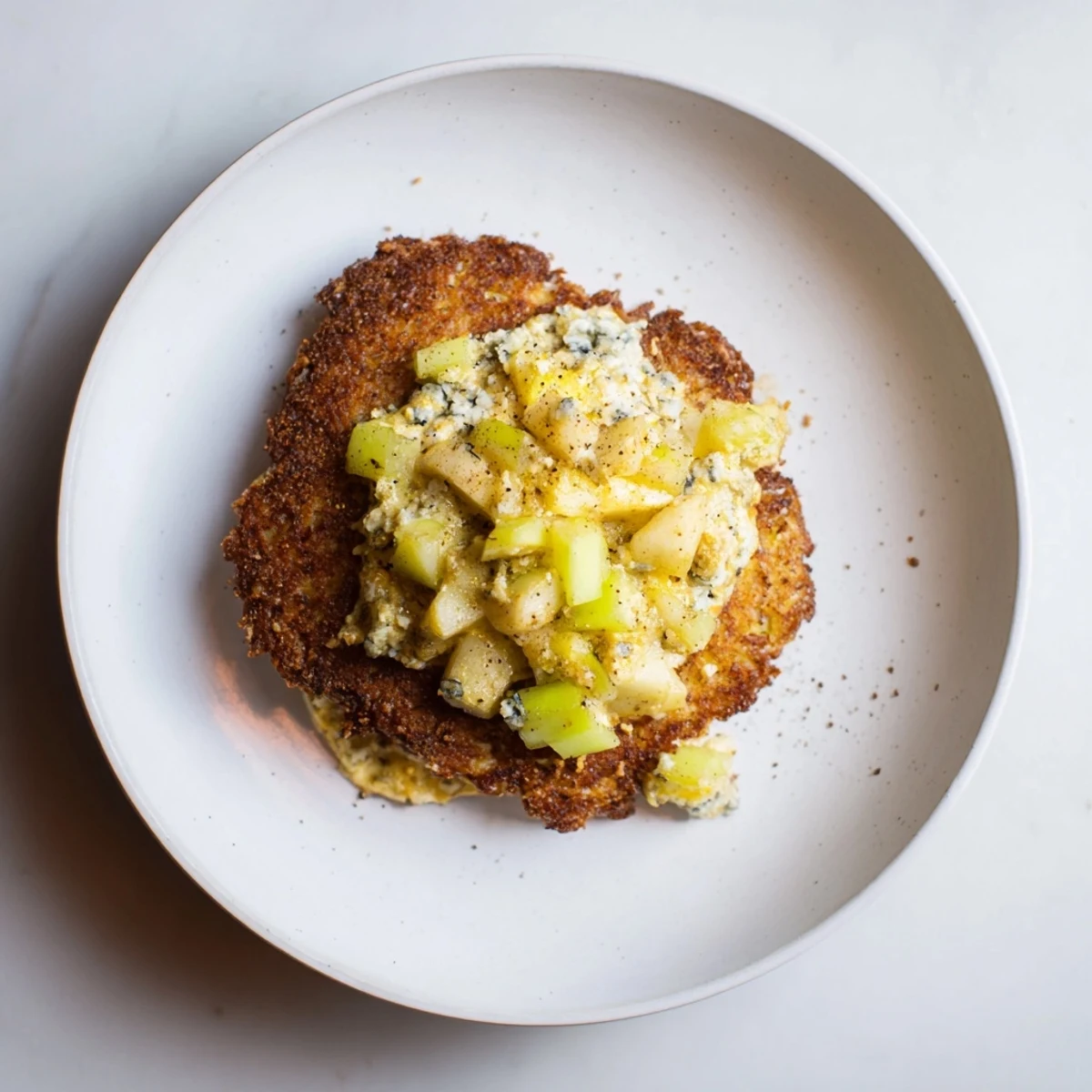 Golden-brown budget potato pancakes served with creamy Gorgonzola-apple compote, ready to eat.