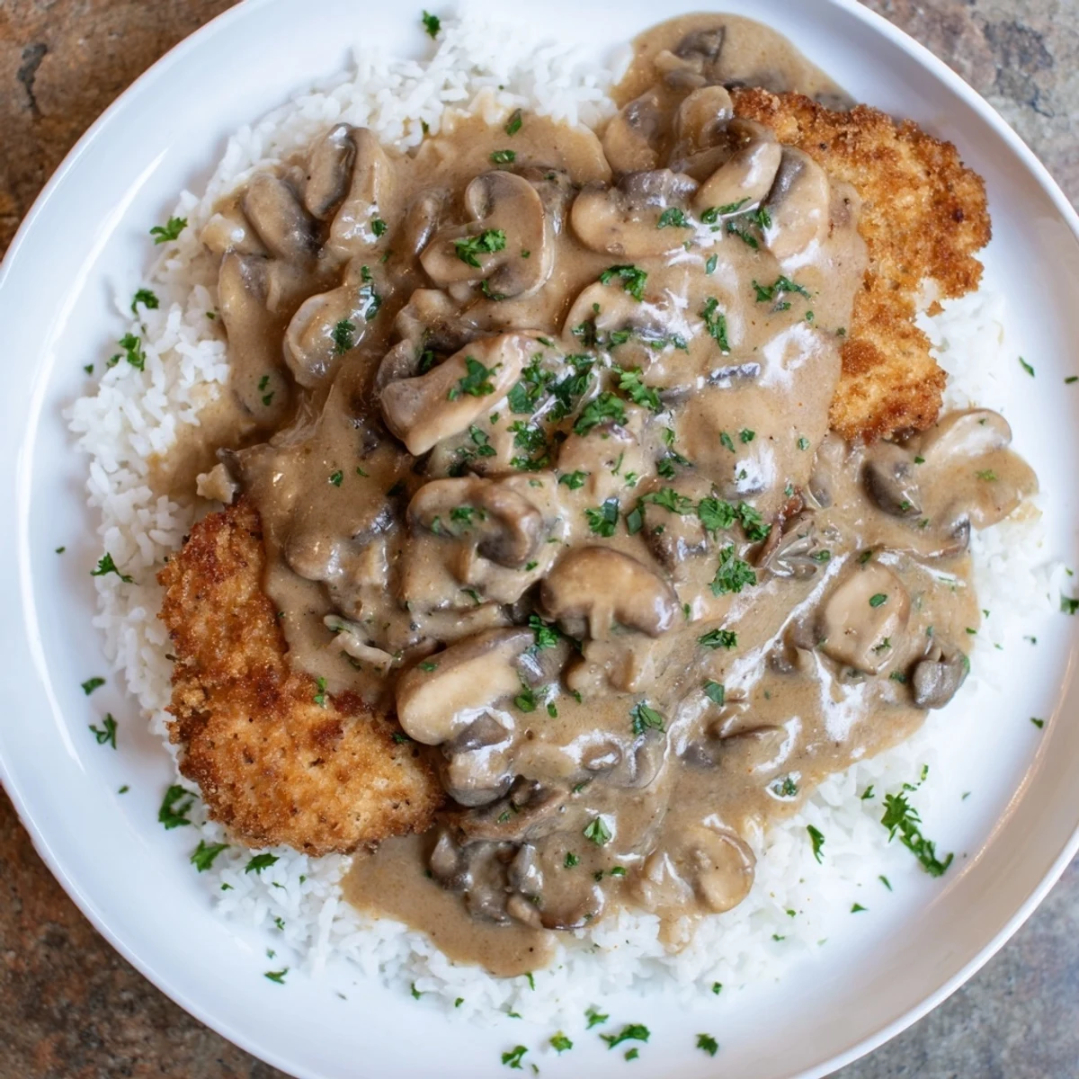 Crispy, golden Jaeger Schnitzel sits beneath rich mushroom gravy, ready for a satisfying dinner.