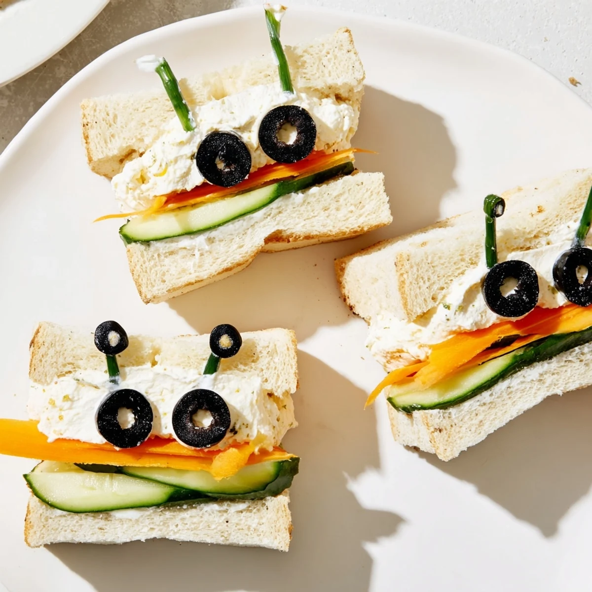Adorable bee sandwiches with cucumber and carrot, ready for a kid's party on a colorful board.