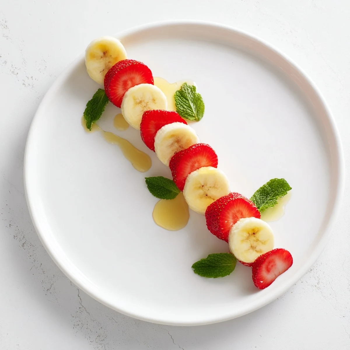 Vibrant candy cane made of banana and strawberry rounds, a festive and delicious recipe to try.