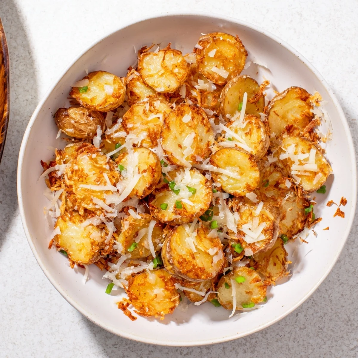 Golden, crispy edges of Parmesan Smashed Potatoes, garnished with fresh herbs, ready to serve.