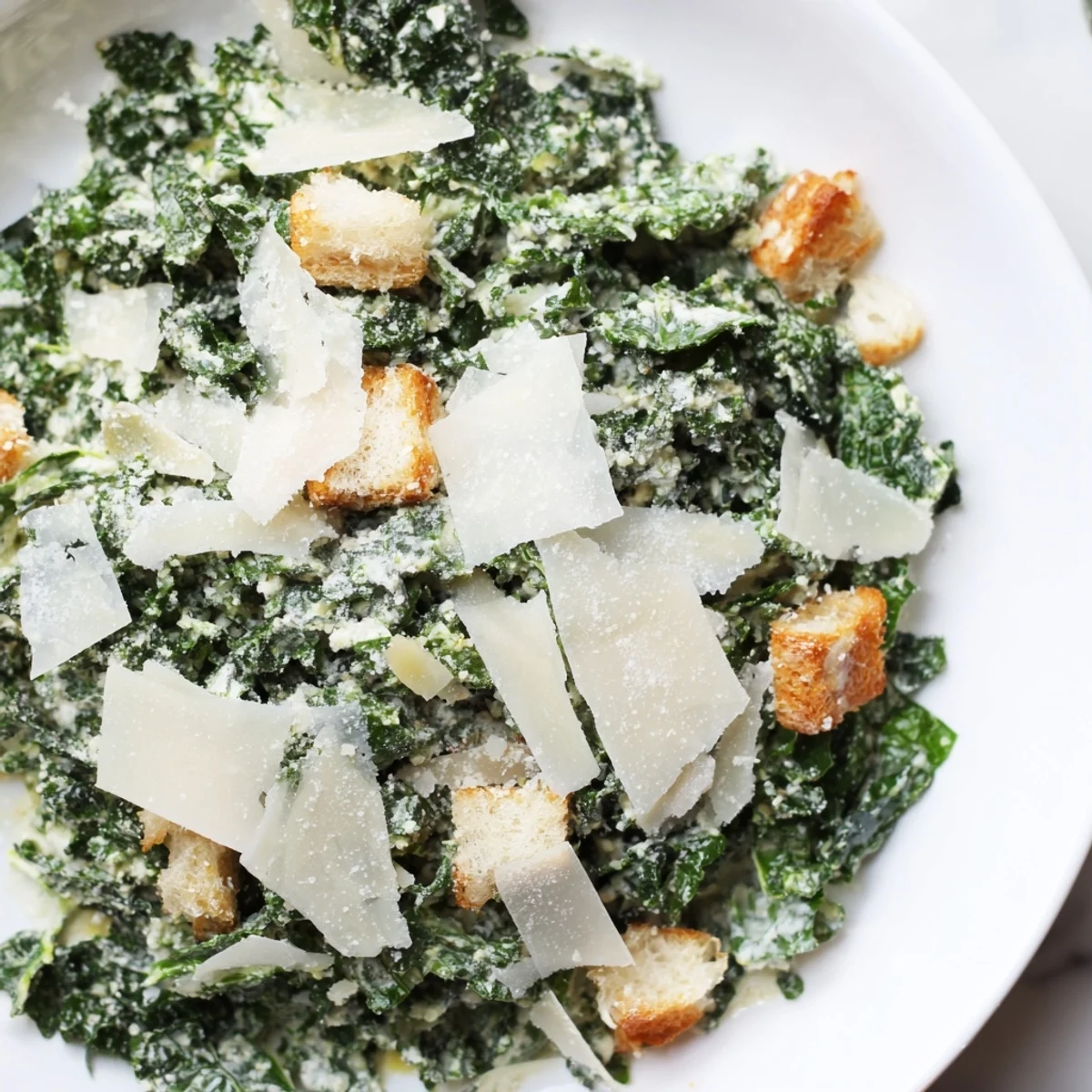 A close-up of a vibrant Kale Caesar Salad, showcasing crunchy croutons and shaved Parmesan.