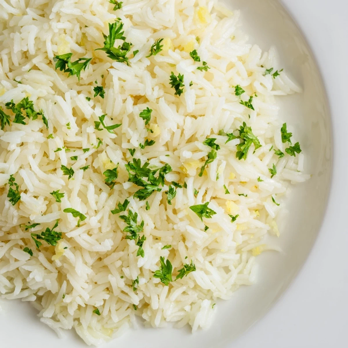 Close-up of golden-hued garlic butter rice, a flavorful side dish with fresh parsley garnish.