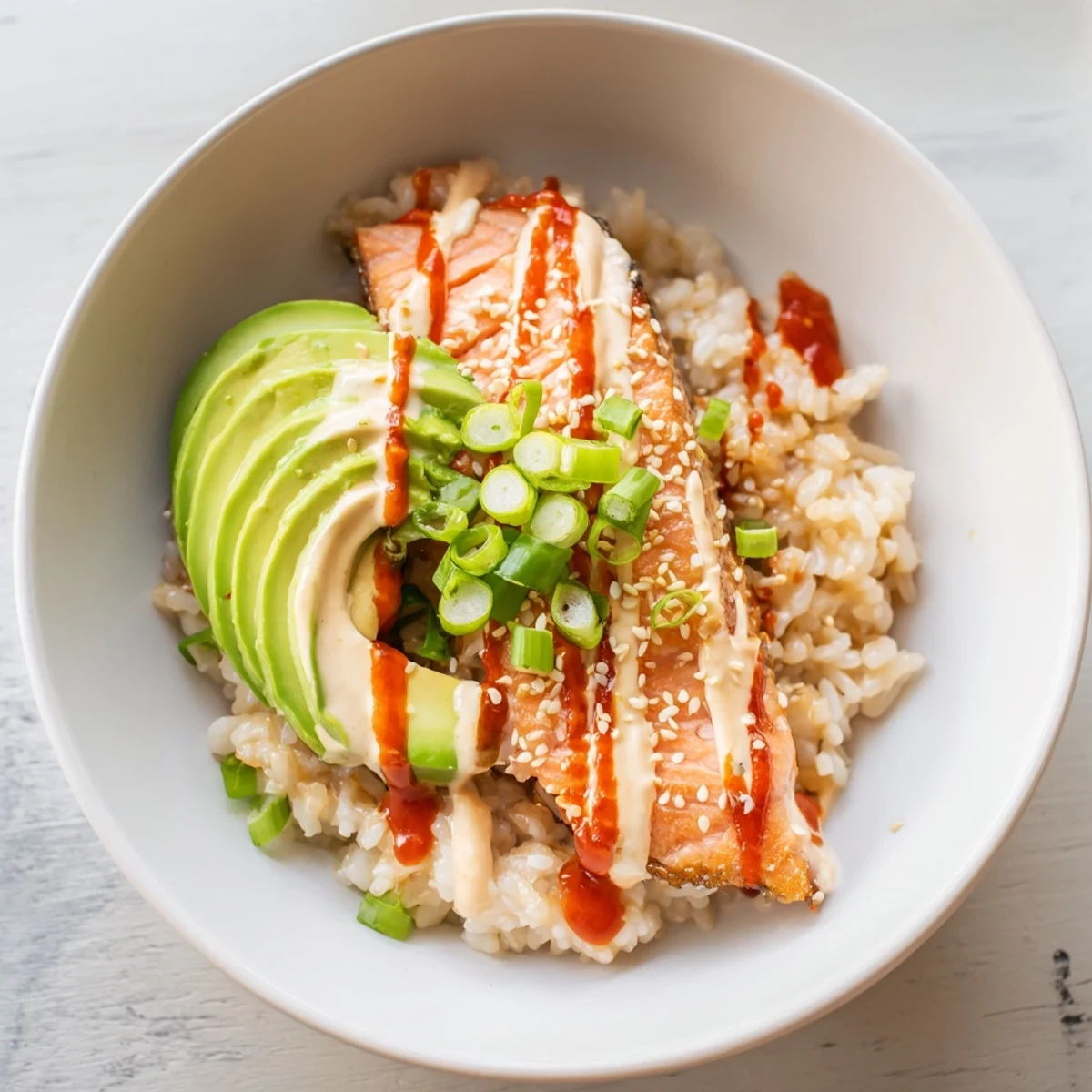 Fluffy rice and flaked salmon in an Emily Mariko Salmon Rice Bowl, ready for a delicious bite.
