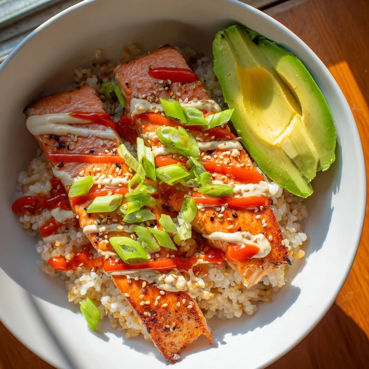 This colorful Emily Mariko Salmon Rice Bowl features creamy avocado and crispy seaweed, perfect for lunch.