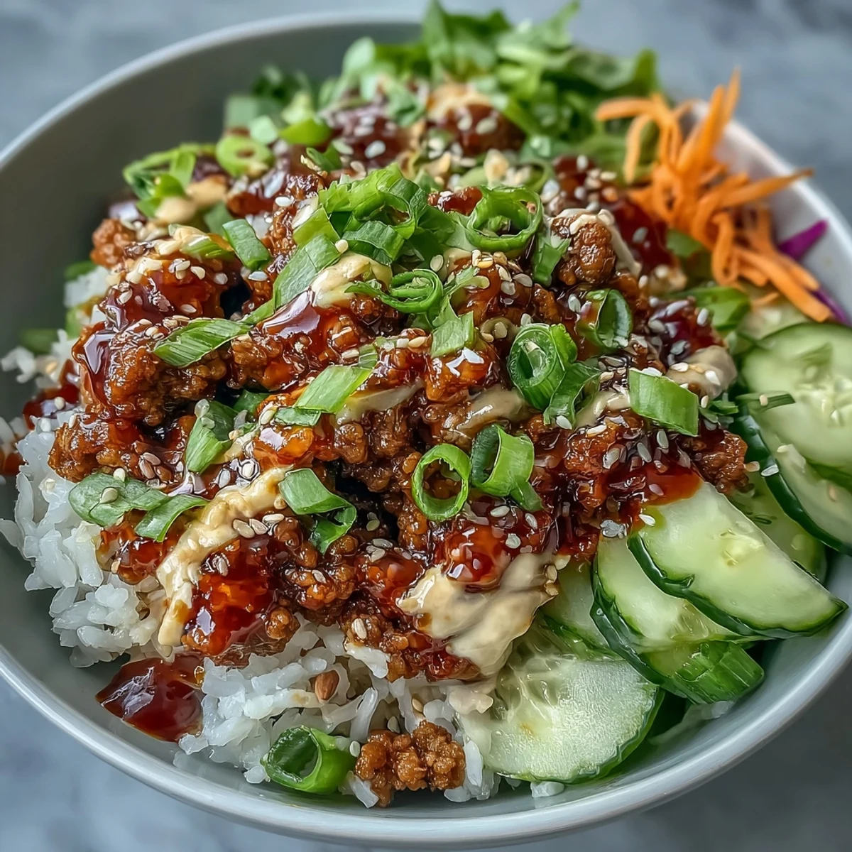 Spicy Bang Bang Turkey Rice Bowls topped with crisp veggies and creamy sauce, drizzled with sesame seeds.