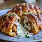 Decadent Chicken Pillows with Garlic Parmesan Sauce baked golden, resting on a plate next to a fresh green salad.