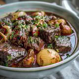 Genieße das würzige Wild Mushroom Beef Bourguignon mit goldbraunen Karotten in reichhaltiger Rotweinsoße.