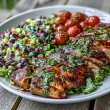 Juicy Grilled Lime Cilantro Chicken paired with colorful corn and black bean salad and warm tortillas on a sunny table.