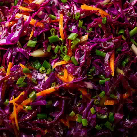 Ein großer Haufen frischer roter Kohlrabi mit vielen grünen Zwiebeln.