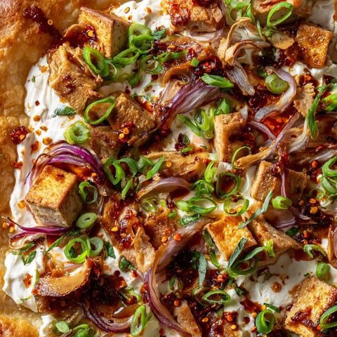 Ein Flammkuchen mit verschiedenen Zutaten wie Chili-Crisp, Onion, Zwiebeln und Knoblauch.