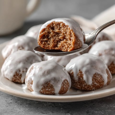 Ein weißer Teller mit Pfeffernüsse, die mit Lebkuchen-Glasur bedeckt sind.