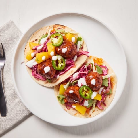 Saftige Currywurst-Tacos mit würziger, eingelegter Mango und frischem Gemüse.