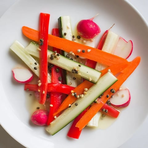 Knisprige, säuerliche eingelegte Gemüsesticks im leuchtenden Glas serviert.  