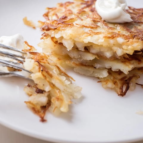 Knusprige deutsche Kartoffelpuffer, serviert mit Apfelmus und Sauerrahm, verlockend!  