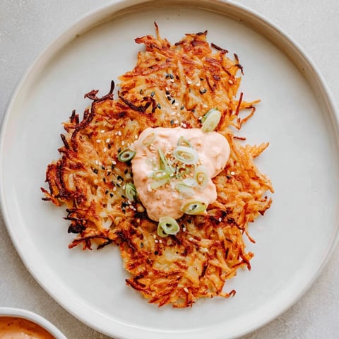 Golden, crispy Kartoffelpuffer, ready to eat with a creamy and vibrant kimchi yogurt dip.