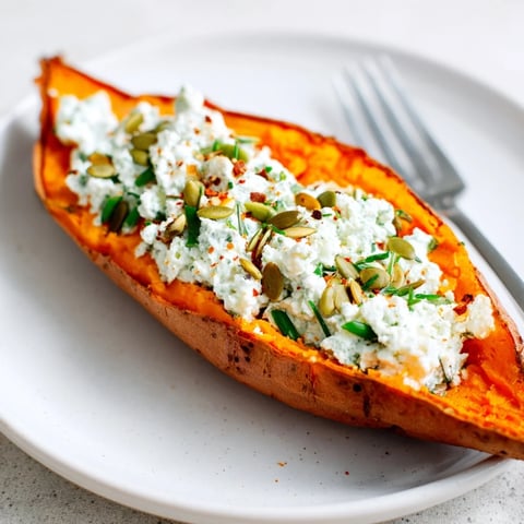 An oven-baked sweet potato stuffed with cottage cheese and herbs, a wholesome, colorful vegetarian meal.