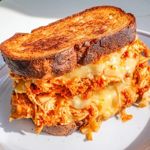 Spicy Crispy Chicken Sandwich Grilled Cheese: a close-up showing golden-brown, cheesy goodness, enticing textures.