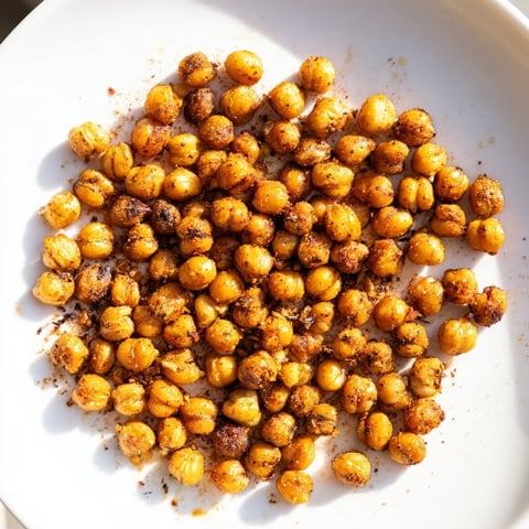 Crispy Chickpea Snack image: Golden, crunchy oven-roasted chickpeas sprinkled with spices, ready for a flavorful snack.