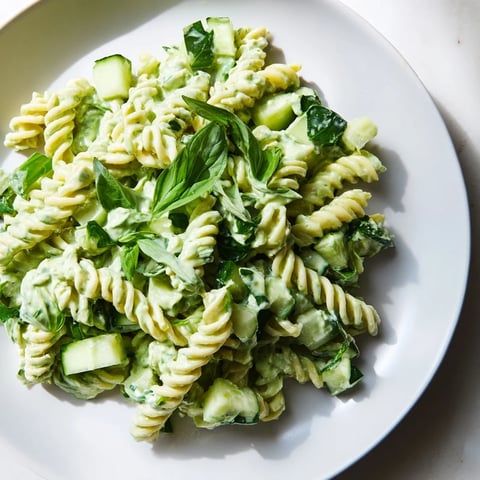Creamy green goddess pasta salad with fresh herbs and colorful diced vegetables, ready to eat.