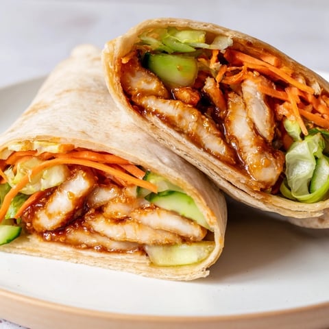 Juicy Honey Chili Crunch Chicken Wraps, filled with crisp veggies, are ready to eat.