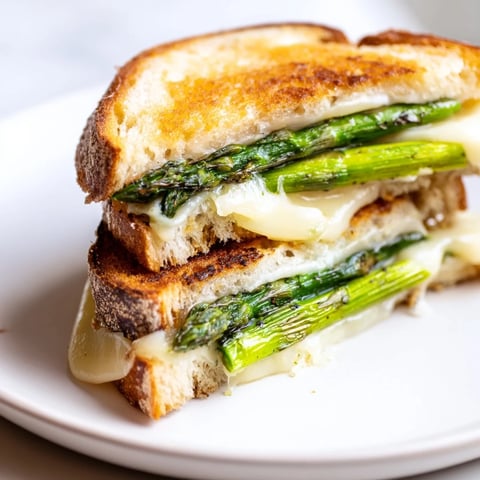Golden-brown Asparagus & Brie Grilled Cheese, with melted cheese and grilled asparagus filling the crispy bread.