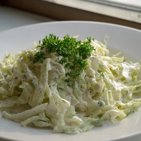 Creamed cabbage with silky, tender leaves in a light, creamy sauce served as a warm side dish