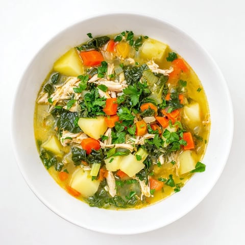 Bowl of steaming Collard Greens, Chicken and Vegetable Soup with tender shredded chicken and bright greens