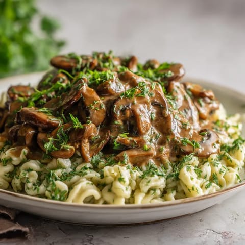 Ein Plate mit Mushroom Stroganoff und Herb Spaetzle.