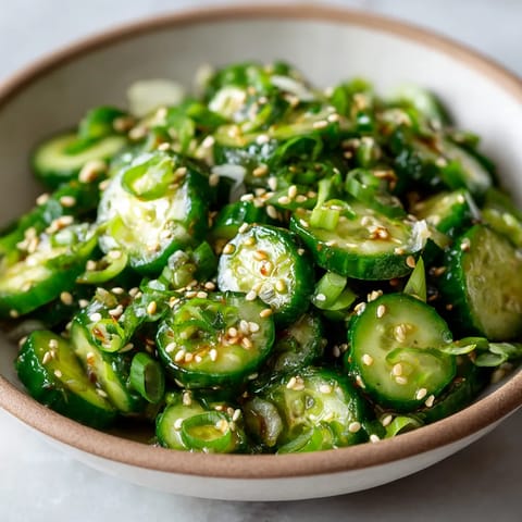 Ein weißer Becher mit einer Mischung aus grünen Zucchini, Sesam und Kräutern.