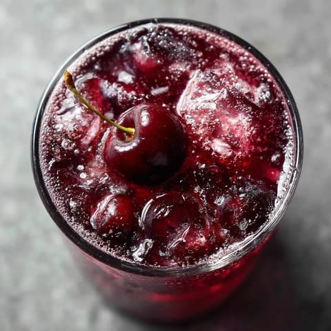 Ein Glas mit einem Cherry, das in den Kaffee getaucht ist.