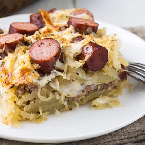 Selbstgemachter Sausage & Sauerkraut Casserole im Auflaufgericht, dampfend und golden gebacken.