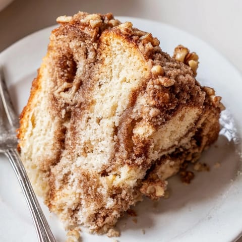 Hausgemachter Cinnamon Streusel Coffee Cake: Eine warme Scheibe mit frisch gebrühtem Kaffee genießen.