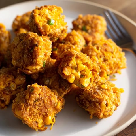 Golden brown Smoky Pretzel Cheddar Corn Nuggets served alongside zesty dipping sauces.  