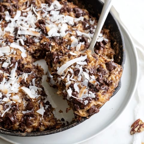 Der köstliche, warme German Chocolate Skillet Cookie mit schmelzenden Schokoladenstückchen.  