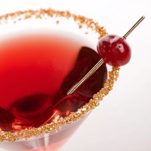 Gleaming martini glass showcasing a Rococo Kirsch Martini, cherry and gold hues.
