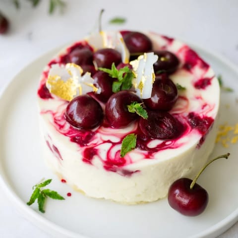 Rich and creamy Cherry Vibe Cheesecake, with a delicate Rococo pattern and fresh cherries.