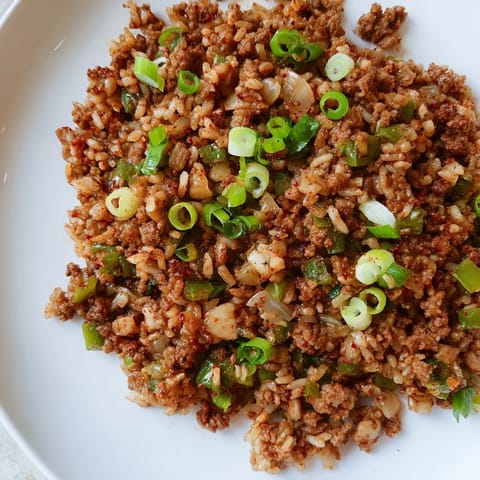 A steaming bowl of Cajun Dirty Rice, a Southern comfort food classic, with visible spices.