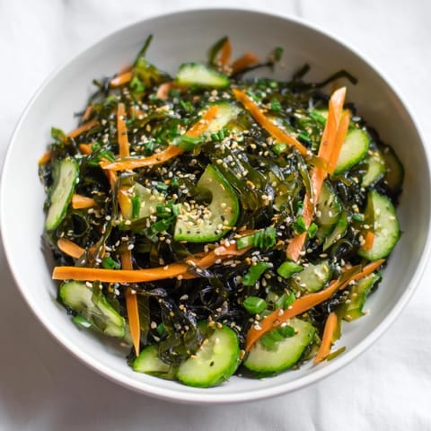 Seaweed Salad mit würziger Sesam-Ginger-Dressing und roten Chili-Flocken garniert.  