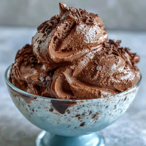 A creamy bowl of chocolate protein fluff, prepared with Greek yogurt and cocoa powder, ready for a post-workout treat.