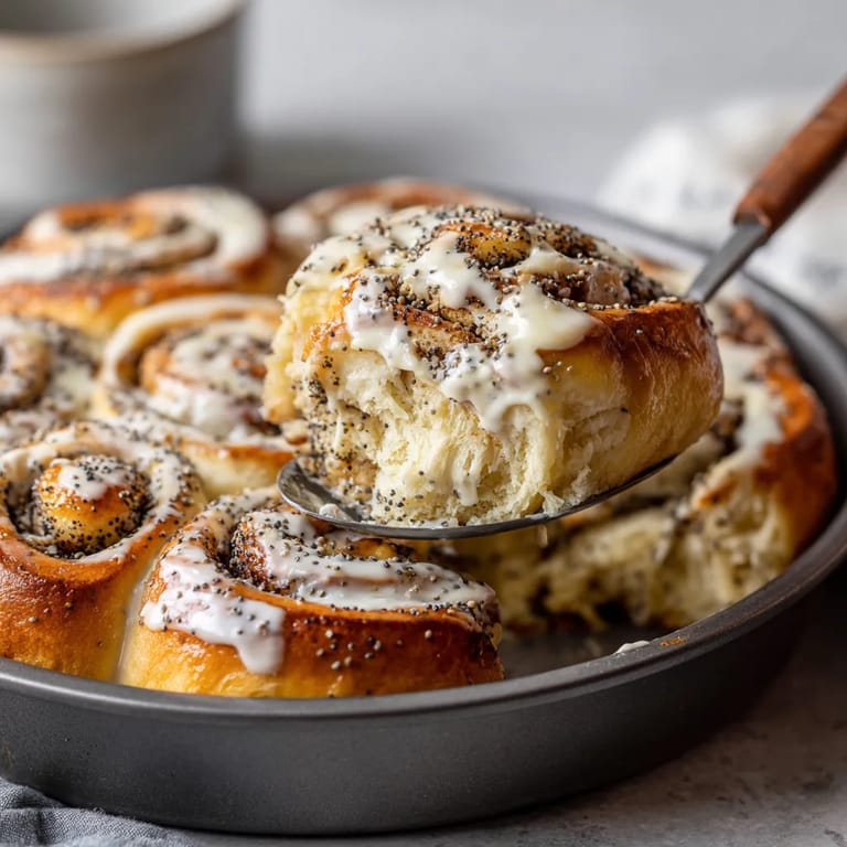 Ein Teller mit Poppy Seed Rolls, die mit weißem Schokolade und Sesamkörnern garniert sind.