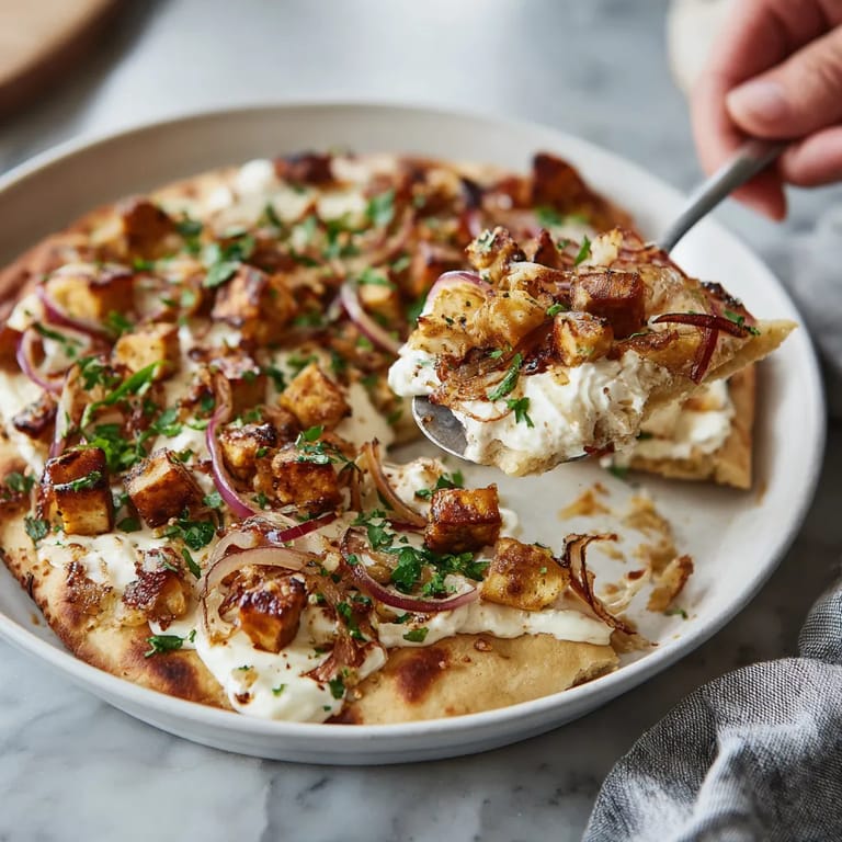 Ein Flammkuchen mit einer veganen Creme und geröstetem Tofu.