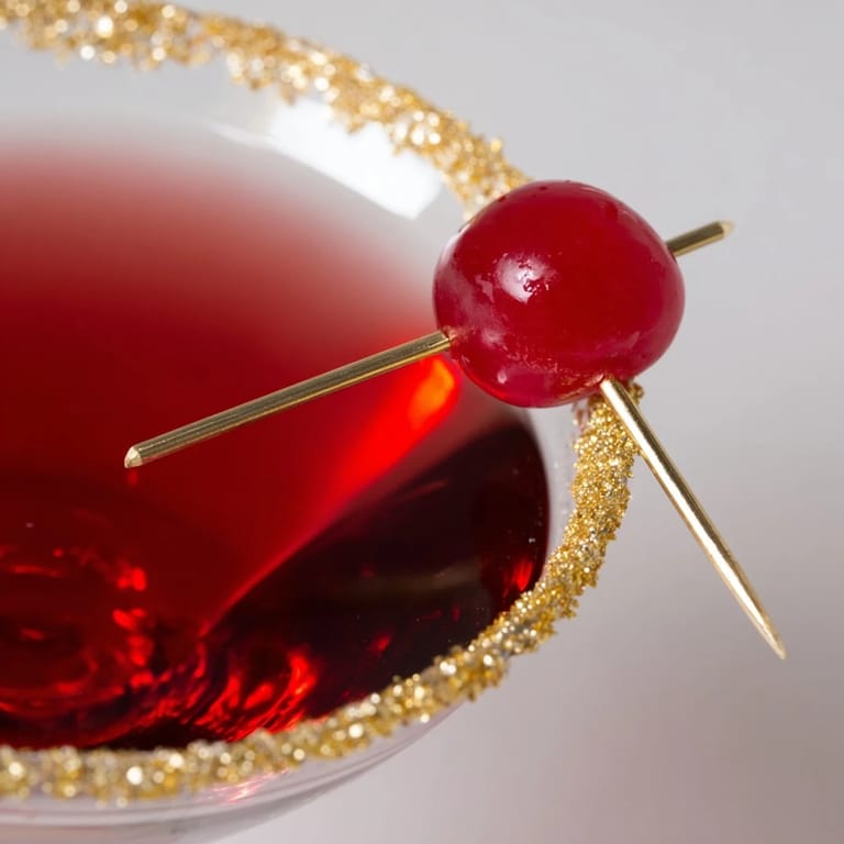 Elegant presentation of a chilled Rococo Kirsch Martini, garnished with a bright cherry.