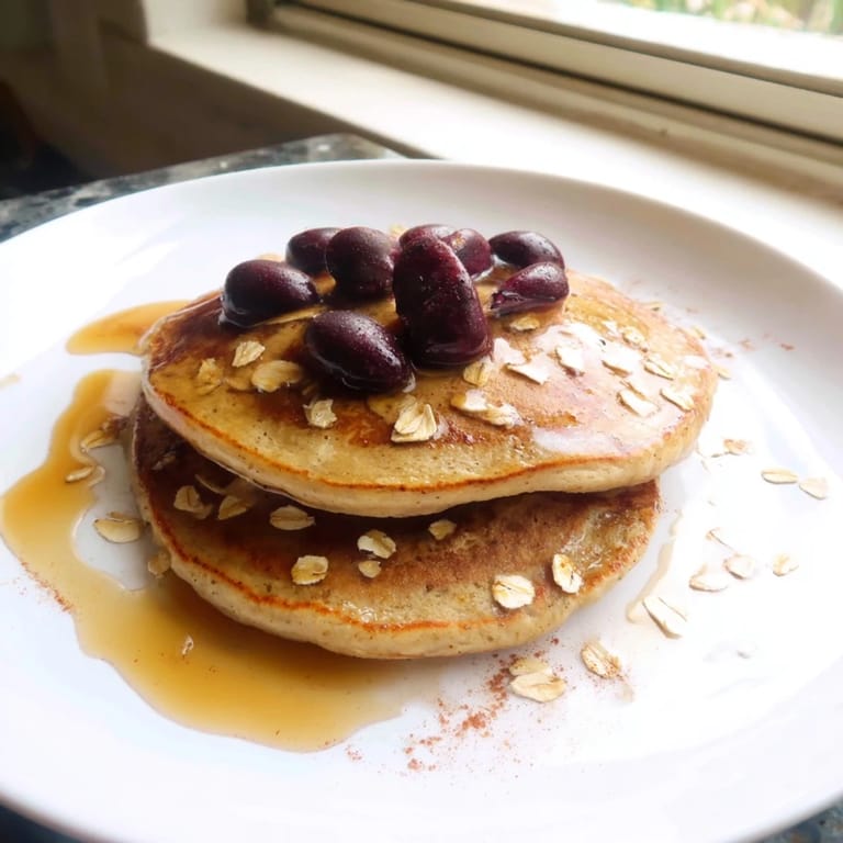 A stack of fluffy banana oat pancakes, perfect for dipping in warm maple syrup.