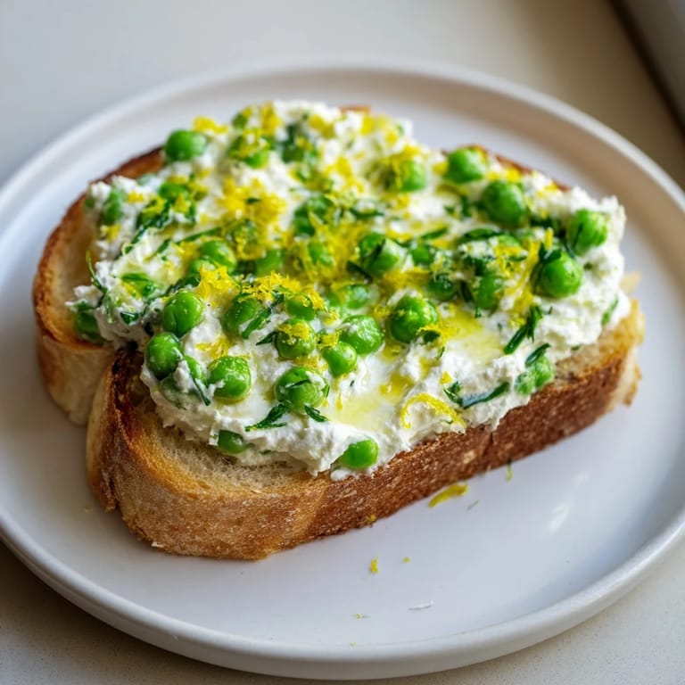 Golden sourdough topped with pea & mint ricotta: a flavorful, fresh breakfast toast.