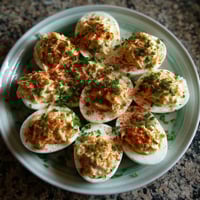 Ein weißer Teller mit sechs Crab-Stuffed Deviled Eggs darauf.